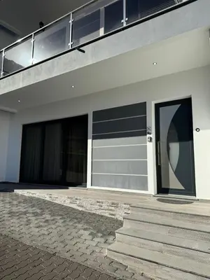 a building with two garage doors and stairs on it at C - Charming Vacation home with FREE Private Parking in Machico