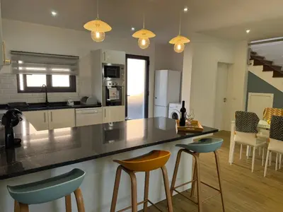 a kitchen with two bar stools and a counter top at C - Charming Vacation home with FREE Private Parking in Machico