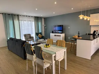 a kitchen and a living room with a table and chairs at C - Charming Vacation home with FREE Private Parking in Machico