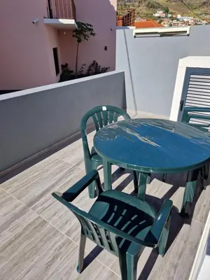 a blue table and a chair on a roof at C - Charming Vacation home with FREE Private Parking in Machico