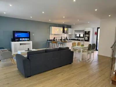 a living room with a couch and a kitchen at C - Charming Vacation home with FREE Private Parking in Machico