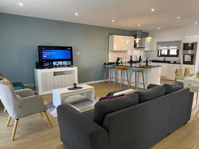 a living room with a couch and a kitchen at C - Charming Vacation home with FREE Private Parking in Machico