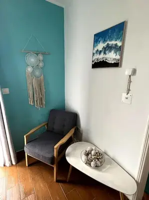 a living room with a chair and a table at Kleines Haus am Meer in Arco da Calheta