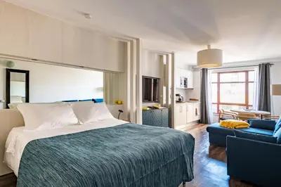 a bedroom with a bed and a blue couch at Marina Club Studio Apartment in Funchal