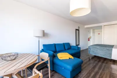 a living room with a blue couch and a table at Marina Club Studio Apartment in Funchal