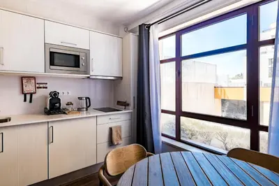 a kitchen with a table and a large window at Marina Club Studio Apartment in Funchal