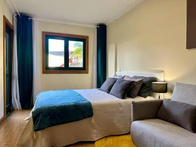a bedroom with a bed and a couch and a window at SUPER Anadia - Turquesa in Funchal