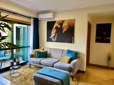 a living room with a gray couch and blue pillows at SUPER Anadia - Turquesa in Funchal