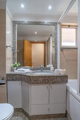 a bathroom with a sink and a large mirror at Monumental Palace in Funchal