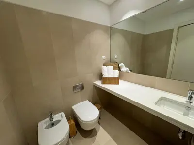 a bathroom with a toilet and a sink and a mirror at Funchal Next Corner Plaza in Funchal