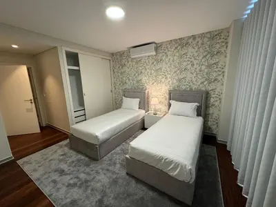 a bedroom with two beds and a rug at Funchal Next Corner Plaza in Funchal