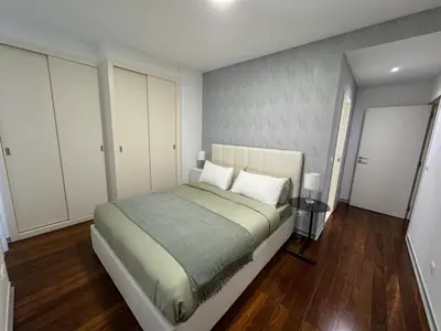 a bedroom with a large bed and white cabinets at Funchal Next Corner Plaza in Funchal
