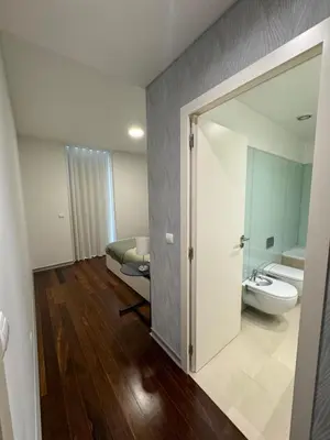 a bathroom with a toilet and a sink and a bed at Funchal Next Corner Plaza in Funchal
