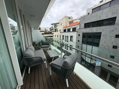 a balcony with chairs and a table on a building at Funchal Next Corner Plaza in Funchal