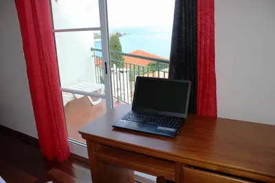 a laptop computer sitting on a desk in front of a window at Moradia Bela House in Santa Cruz