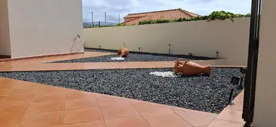a courtyard with two bronze statues on the ground at Moradia Bela House in Santa Cruz