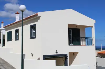 a white building with a street light in front of it at Moradia Bela House in Santa Cruz