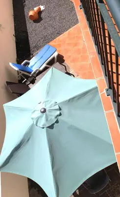 a blue umbrella laying on the ground next to a chair at Moradia Bela House in Santa Cruz