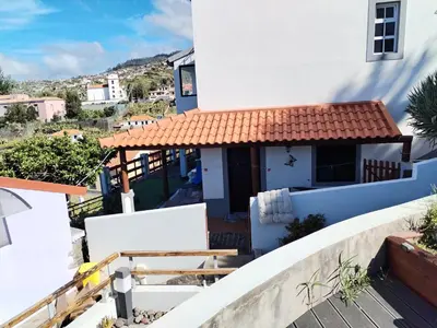 a bedroom with a wooden door and a window at Casa Carreira in Ponta do Sol