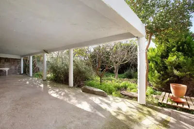 a porch of a house with trees and bushes at Casa Do Lenhador in Canhas
