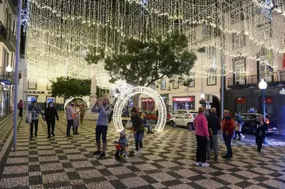 a group of people standing in a street with christmas lights at Sunny Rooftop & perfect view in Arco da Calheta