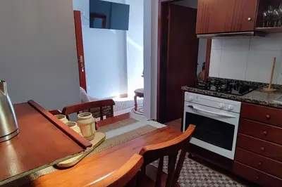 a kitchen with a wooden table and a stove top oven at Sunny Rooftop & perfect view in Arco da Calheta