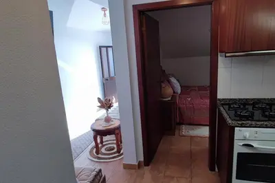 a hallway of a kitchen with a table in a room at Sunny Rooftop & perfect view in Arco da Calheta