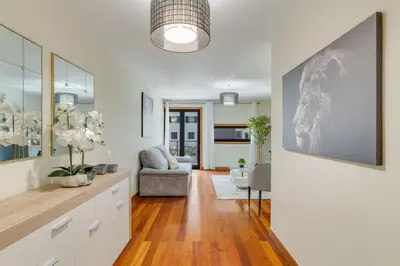 a living room with white walls and wood floors at Lido Charm by Atlantic Holiday in Funchal