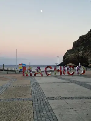 a sign on the beach with the ocean in the background at E - Elegant Terraced Home with FREE Private Parking in Machico