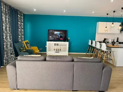 a living room with a couch and a blue wall at E - Elegant Terraced Home with FREE Private Parking in Machico