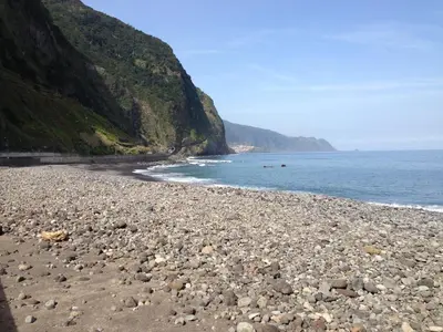 a rocky beach next to the ocean with a mountain at Holidays Madeira in São Vicente