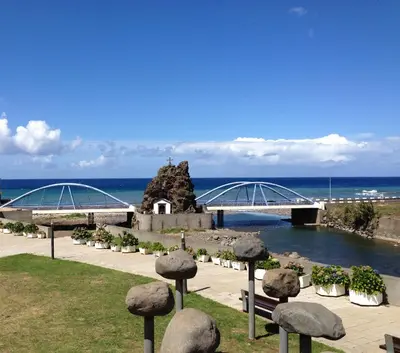a bridge over a body of water with statues of trees at Holidays Madeira in São Vicente