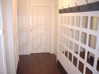 a hallway with a white door and a wall of pictures at Holidays Madeira in São Vicente