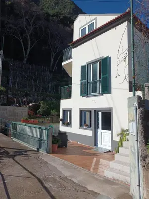 a white house with green shutters and a wooden deck at Sunrise Bay - Modern Flat with stunning views in Seixal