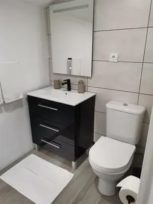 a bathroom with a toilet and a sink and a mirror at Sunrise Bay - Modern Flat with stunning views in Seixal