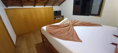 a bedroom with a bed with a brown blanket on it at Refúgio do Limoeiro in São Vicente