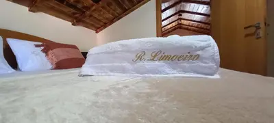 a bed with a white pillow with the word mimosa on it at Refúgio do Limoeiro in São Vicente