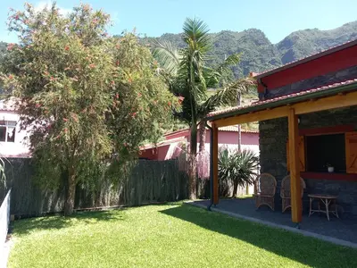 a backyard of a house with a fence and trees at Refúgio do Limoeiro in São Vicente