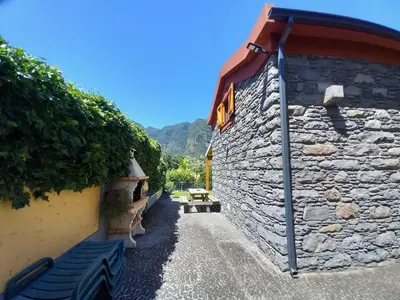 a stone wall with a bench next to a building at Refúgio do Limoeiro in São Vicente