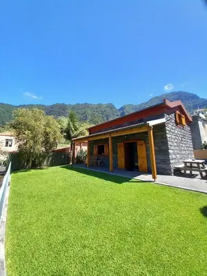 a house with a green lawn in front of it at Refúgio do Limoeiro in São Vicente