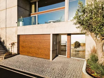a house with a wooden garage door on it at SHELL LIVING - Infinity Loft in Funchal