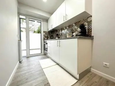 a kitchen with white cabinets and a large window at Pena Apartments - A by MTH in Funchal