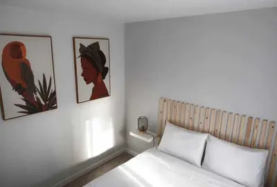 a bedroom with a bed and two pictures on the wall at Pena Apartments - A by MTH in Funchal