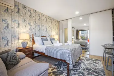 a bedroom with a bed and a living room at White Rabbit I by Homie in Calheta