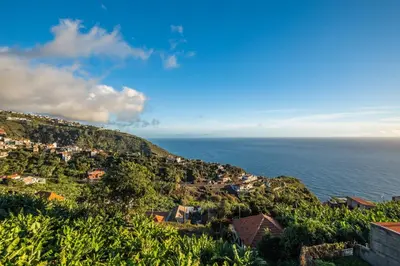 an aerial view of a village on a mountain next to the ocean at White Rabbit I by Homie in Calheta
