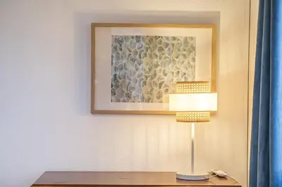 a lamp on a table with a picture on a wall at White Rabbit II by Homie in Calheta