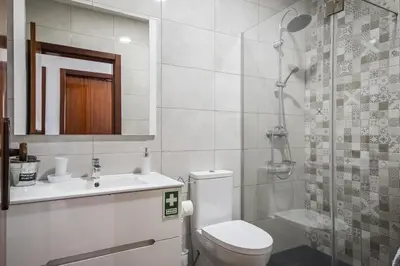 a bathroom with a toilet and a sink and a shower at White Rabbit II by Homie in Calheta
