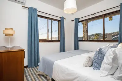 a bedroom with a bed and two windows at White Rabbit II by Homie in Calheta