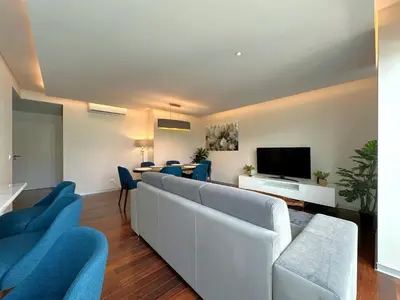 a living room with a white couch and a tv at Luxury Apartment in the Center in Funchal