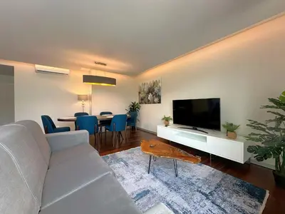 a living room with a couch and a tv and a table at Luxury Apartment in the Center in Funchal